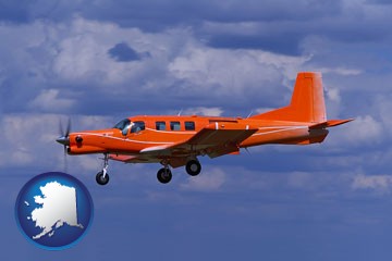a red turboprop aircraft flying in a blue sky with cumulus clouds - with Alaska icon