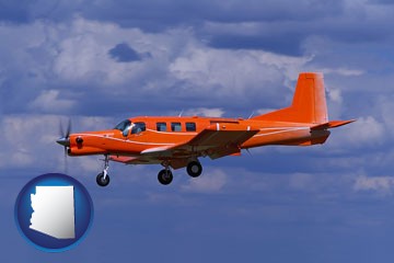a red turboprop aircraft flying in a blue sky with cumulus clouds - with Arizona icon