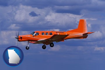a red turboprop aircraft flying in a blue sky with cumulus clouds - with Georgia icon