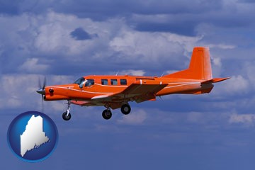 a red turboprop aircraft flying in a blue sky with cumulus clouds - with Maine icon