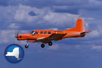 a red turboprop aircraft flying in a blue sky with cumulus clouds - with New York icon
