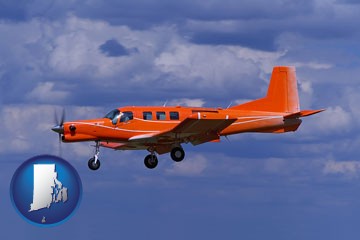 a red turboprop aircraft flying in a blue sky with cumulus clouds - with Rhode Island icon