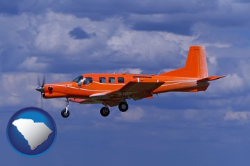 a red turboprop aircraft flying in a blue sky with cumulus clouds - with South Carolina icon