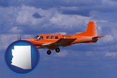 arizona map icon and a red turboprop aircraft flying in a blue sky with cumulus clouds