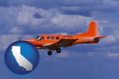 california map icon and a red turboprop aircraft flying in a blue sky with cumulus clouds