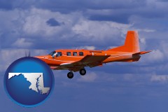 maryland map icon and a red turboprop aircraft flying in a blue sky with cumulus clouds