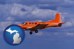 michigan map icon and a red turboprop aircraft flying in a blue sky with cumulus clouds