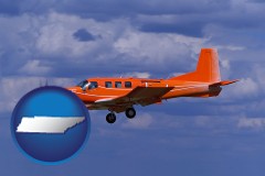tennessee map icon and a red turboprop aircraft flying in a blue sky with cumulus clouds